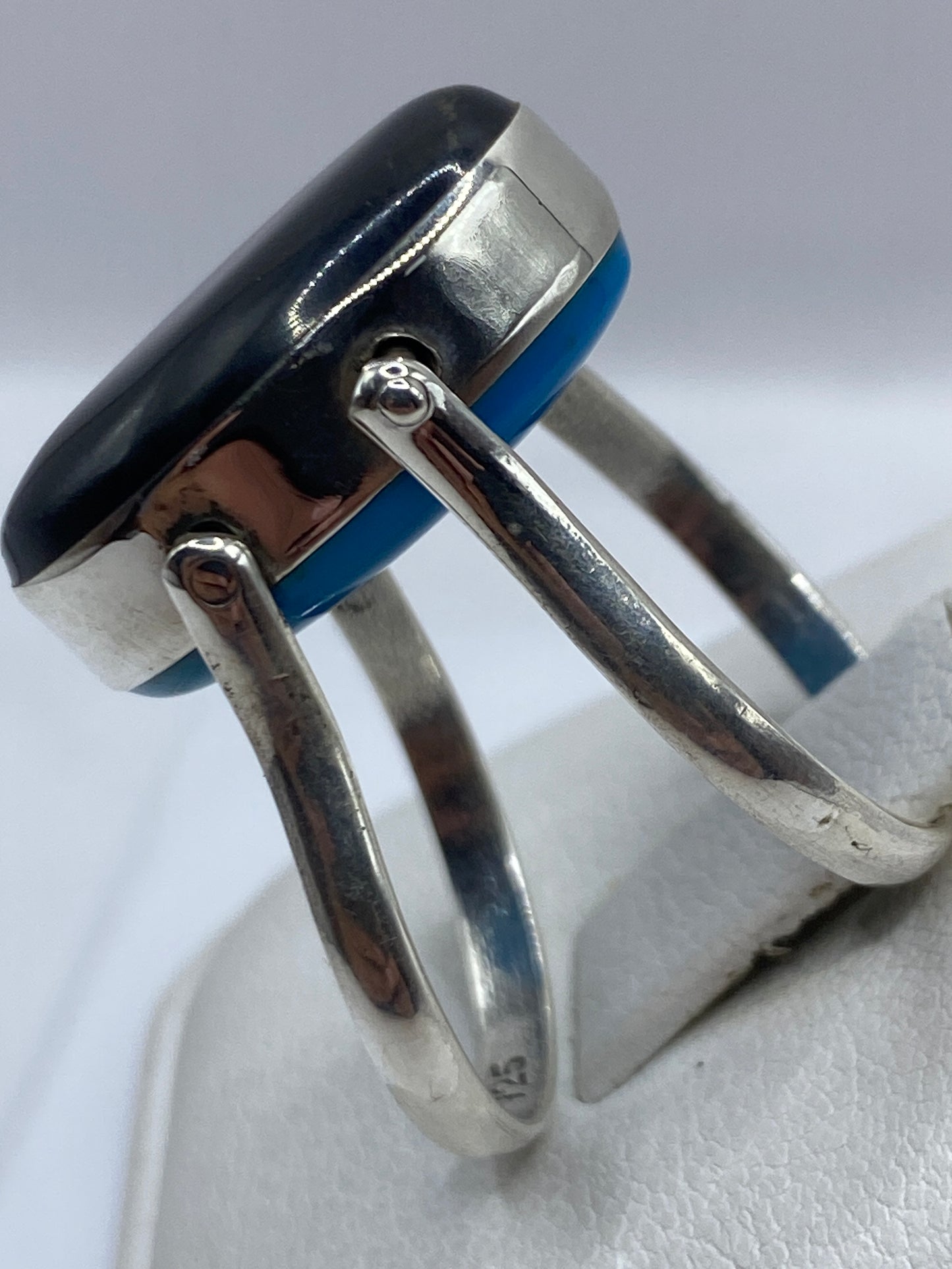 Detalle lateral del anillo mostrando el pulido espejo de la piedra y la plata