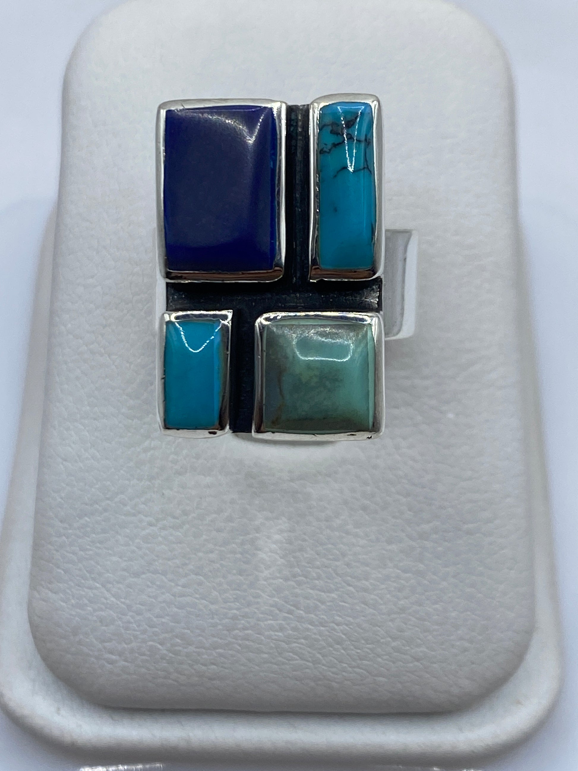 Anillo de plata con turquesa azul cielo de diseño geométrico en la mano