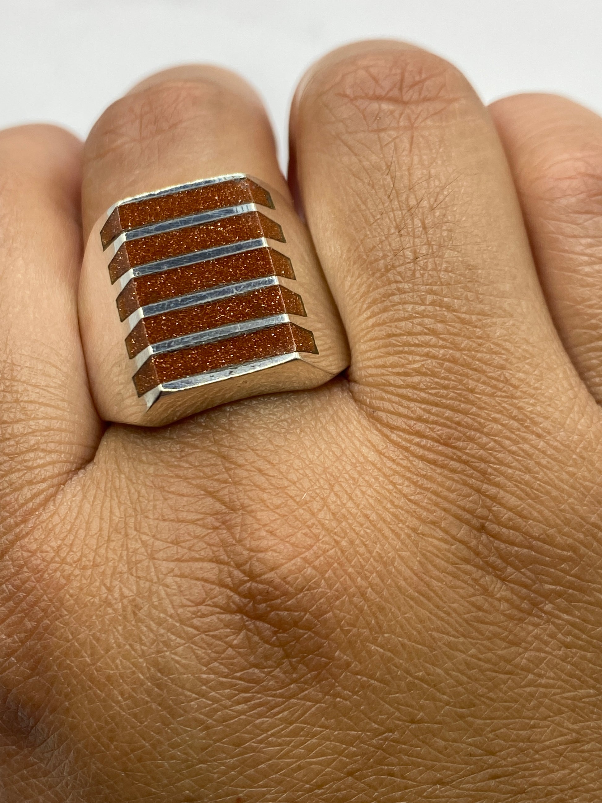 Anillo en dedo masculino mostrando presencia y ajuste en talla 11