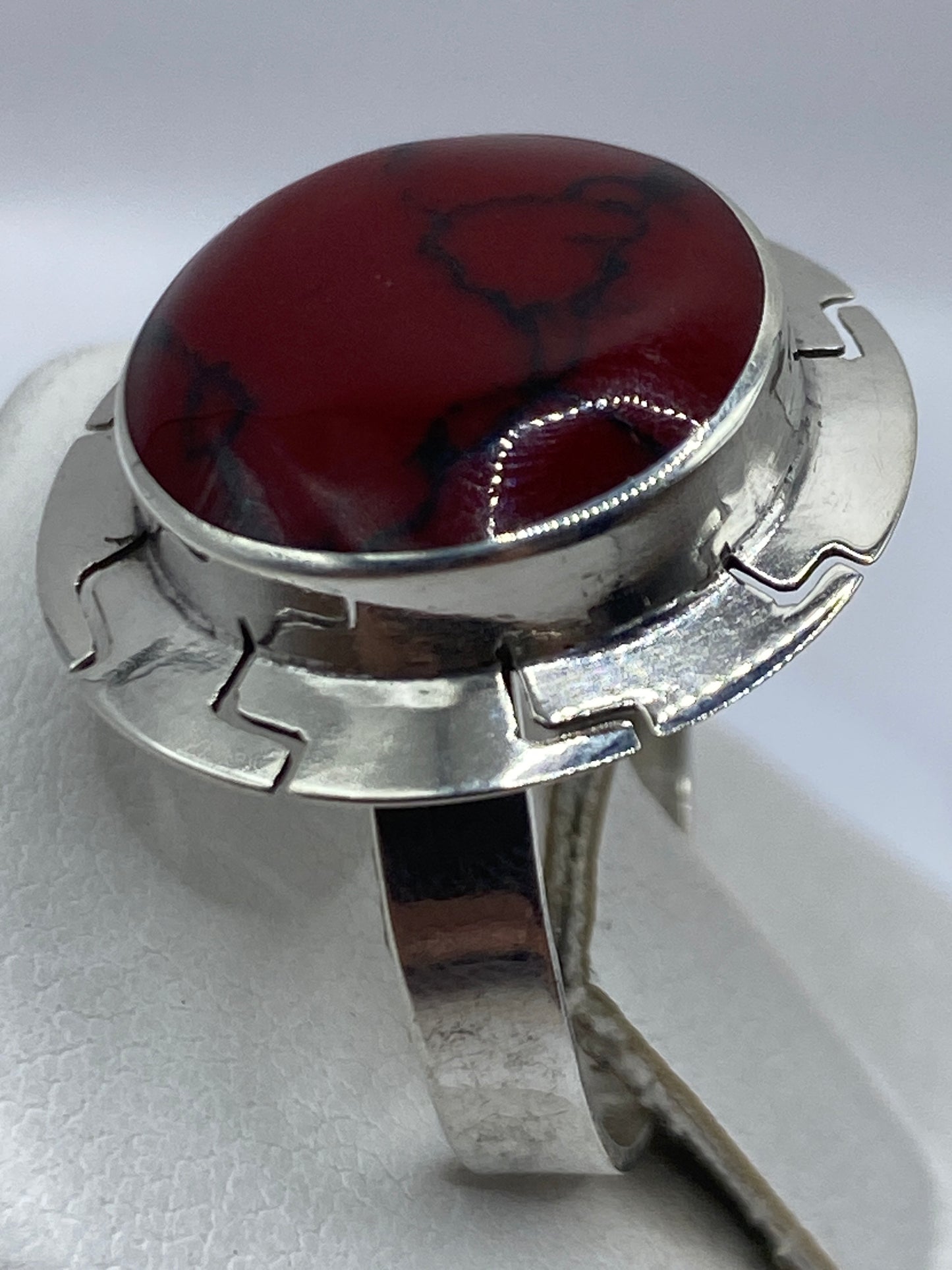 Anillo de coral natural en la mano de una mujer, mostrando el tono rojo profundo