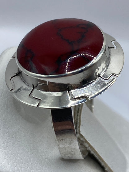 Anillo de coral natural en la mano de una mujer, mostrando el tono rojo profundo