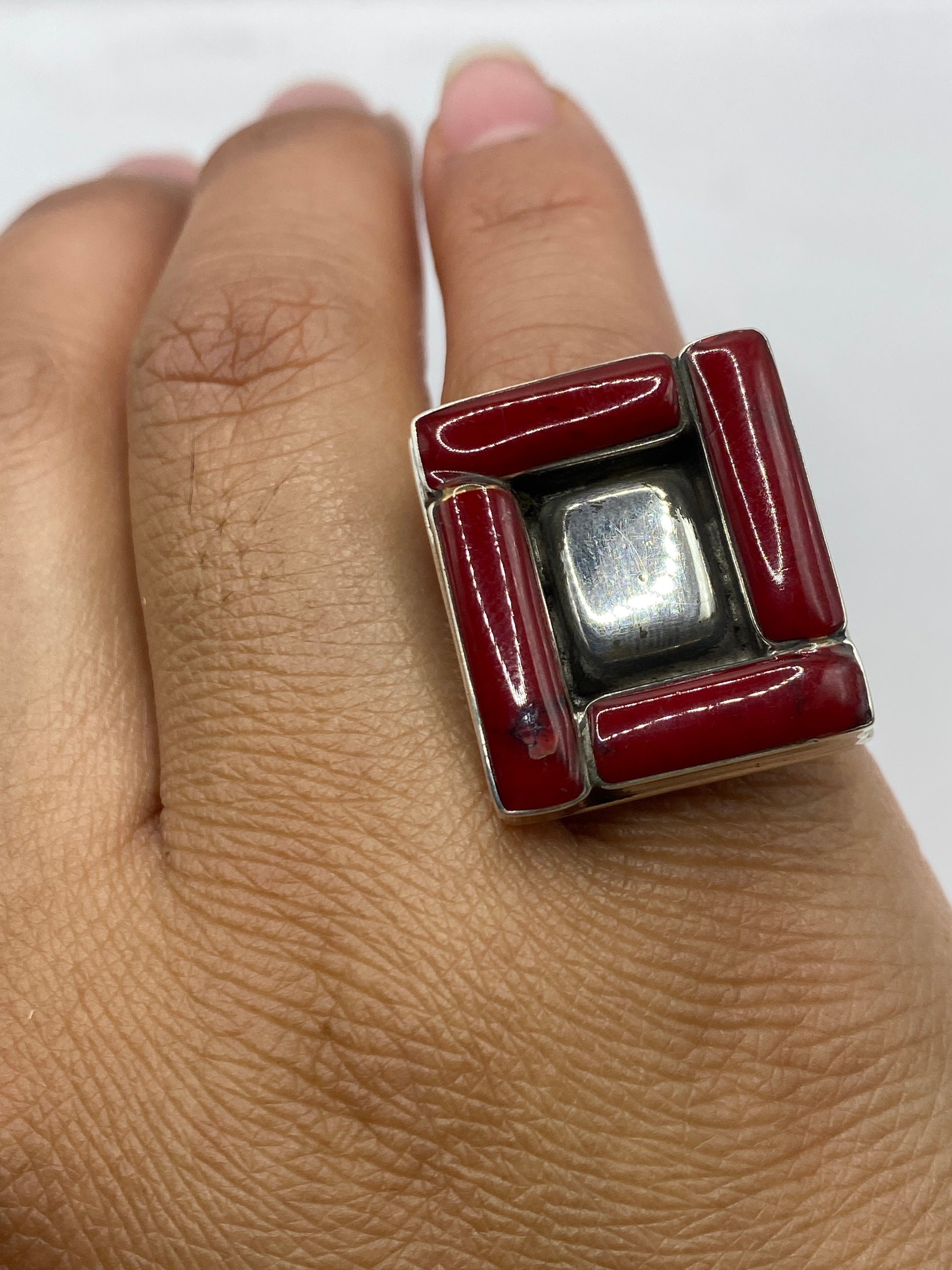 Anillo geométrico de coral rojo sobre balanza mostrando peso de 15.8 gramos