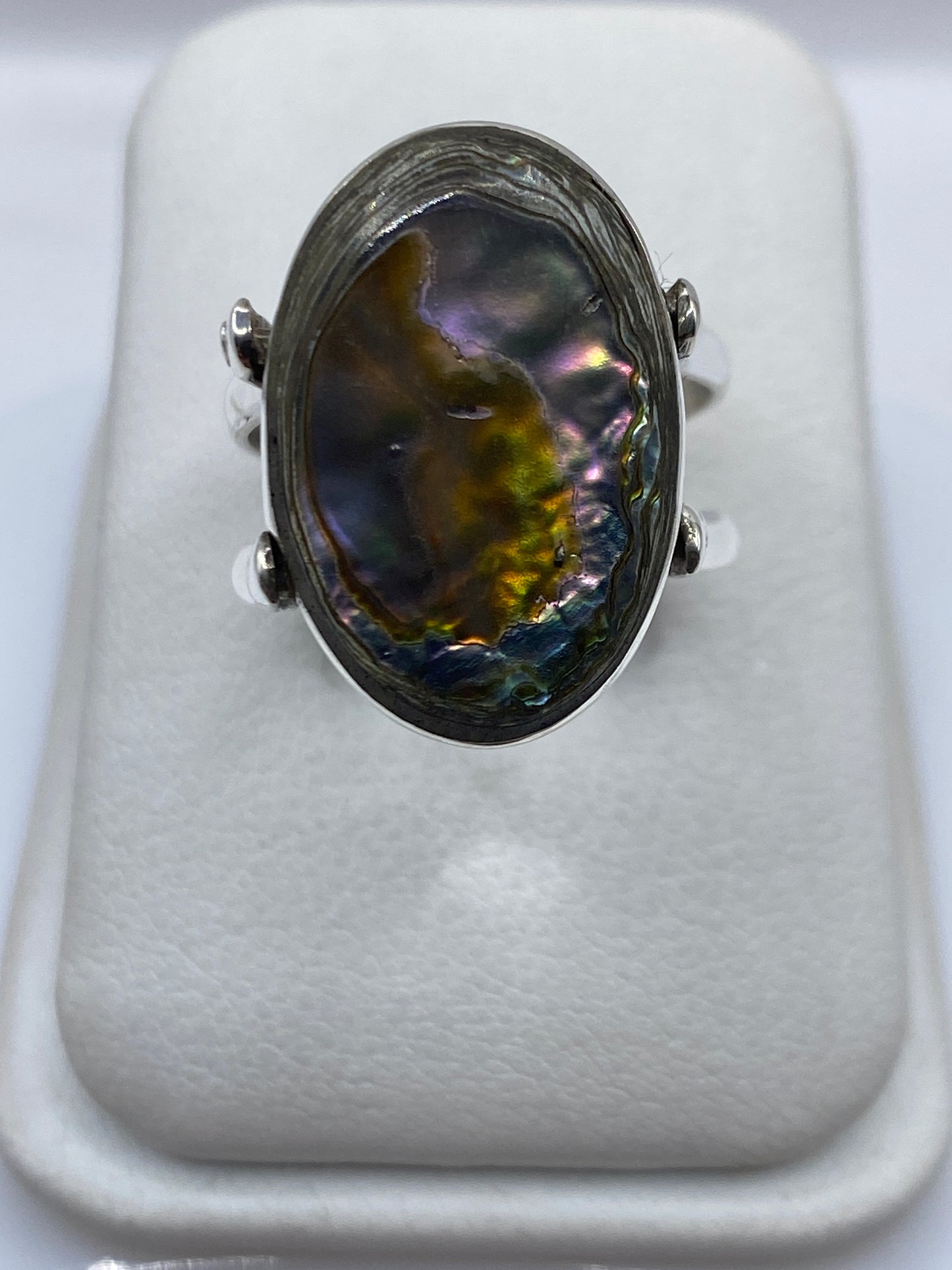 Anillo de plata con ónix negro pulido en la mano de una mujer, vista frontal