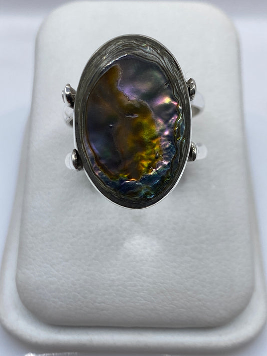 Anillo de plata con ónix negro pulido en la mano de una mujer, vista frontal