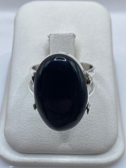 Detalle del ónix negro espejo montado en plata .925, con banda texturizada
