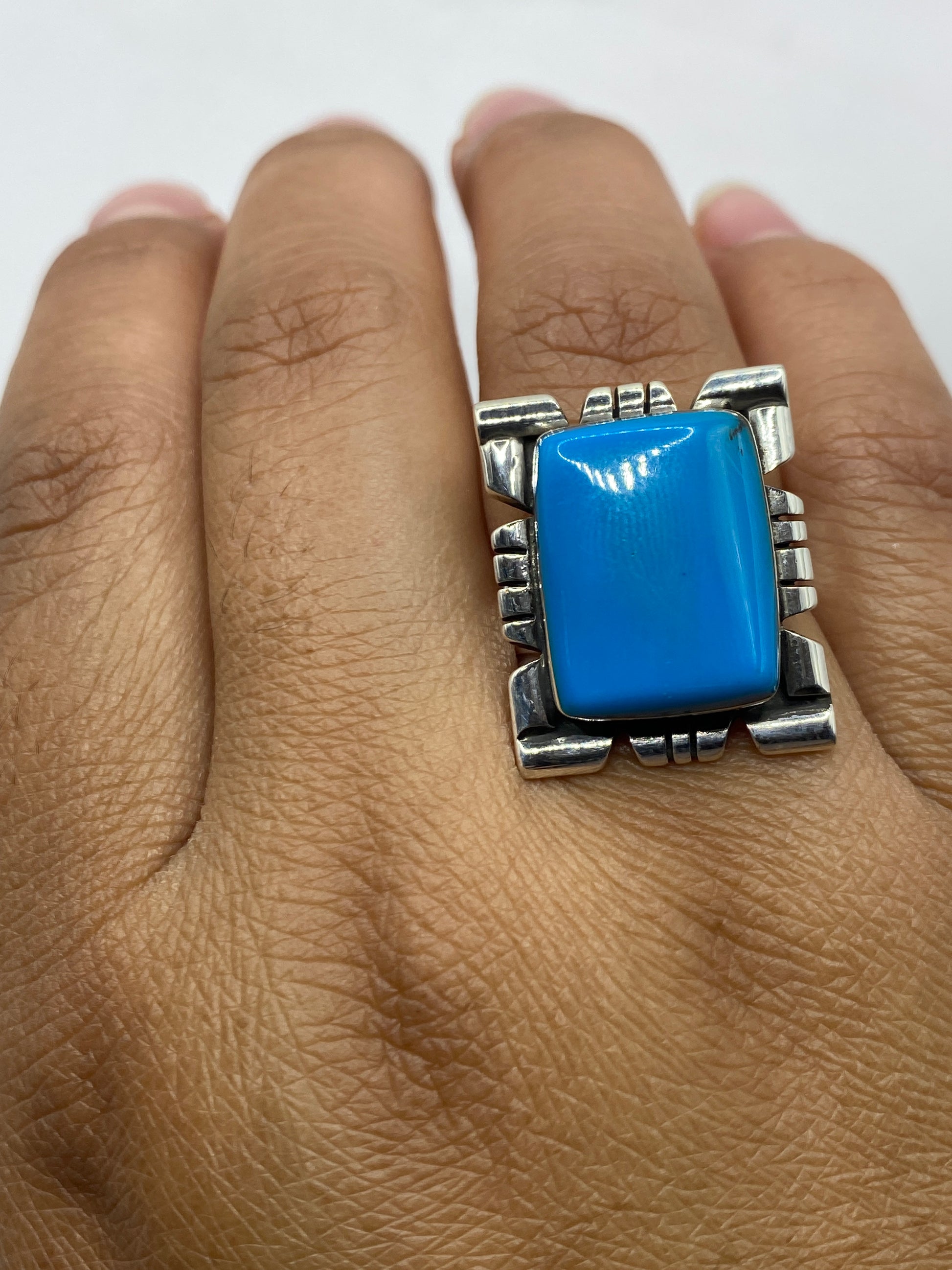 Anillo de piedra azul puesto en el dedo, mostrando el tamaño real y el brillo de la gema