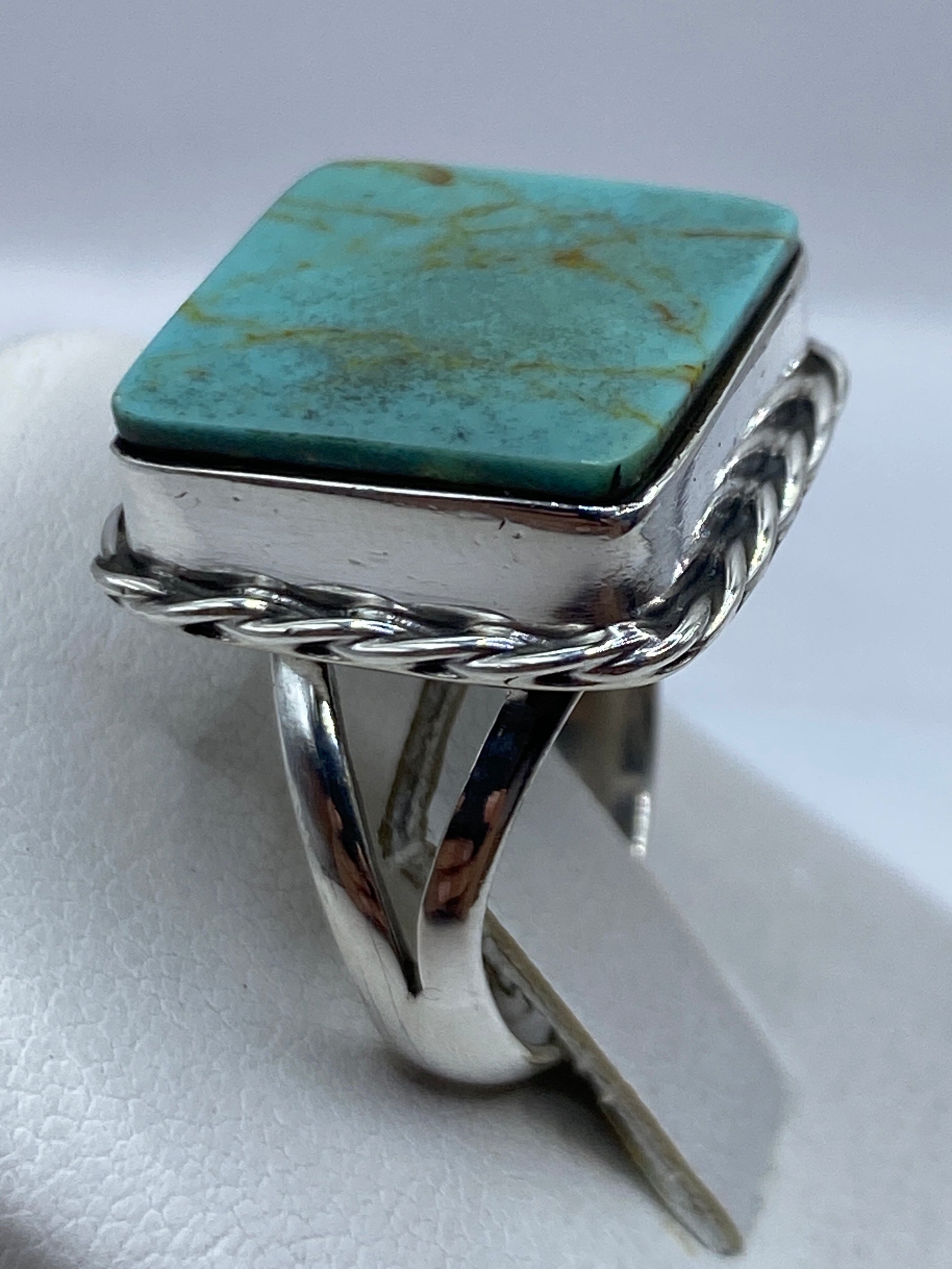 Detalle del frente del anillo con turquesa azul cielo y vetas naturales, engastada en plata
