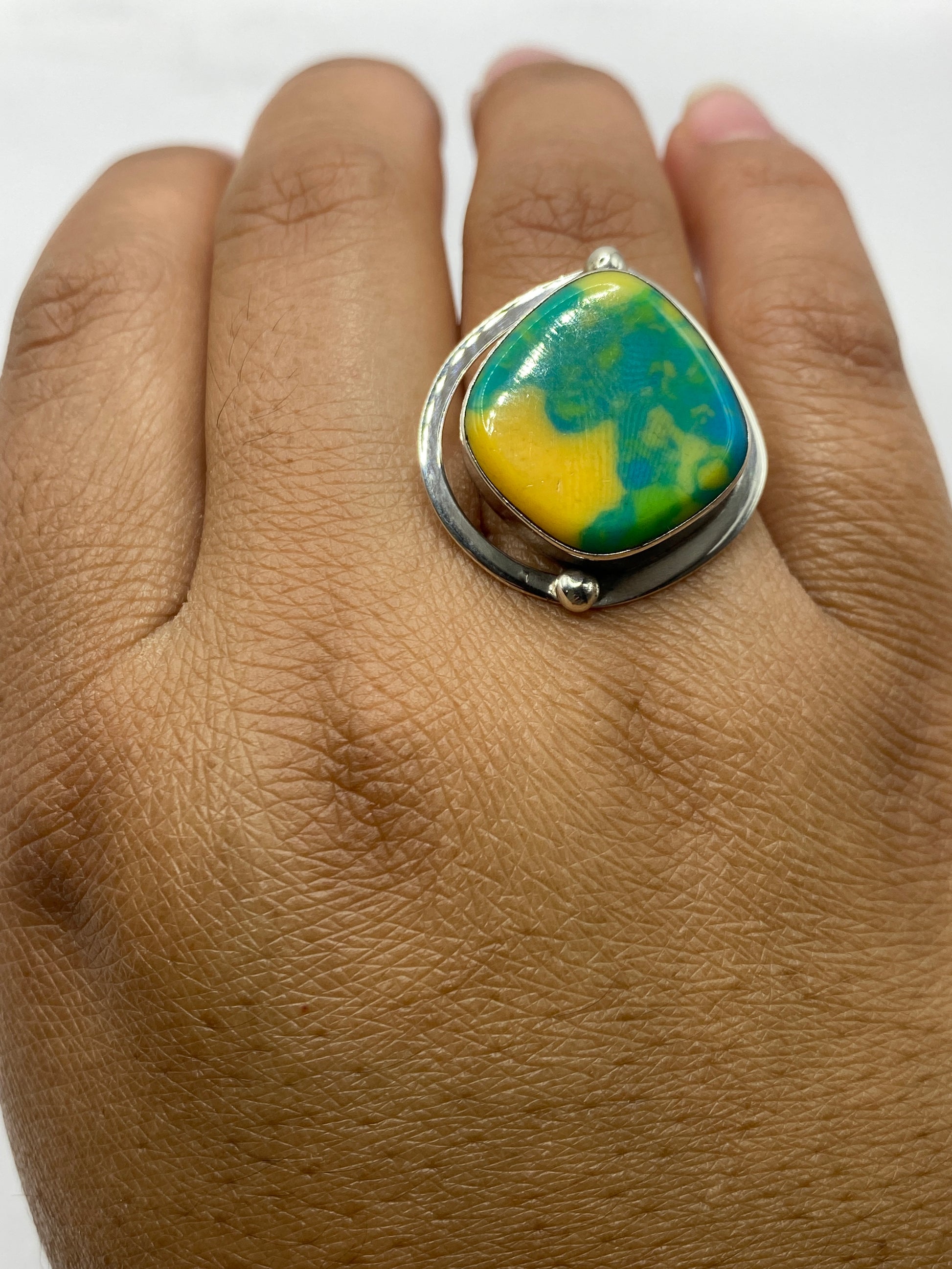 Anillo completo sobre fondo gris mostrando el juego de colores del ópalo