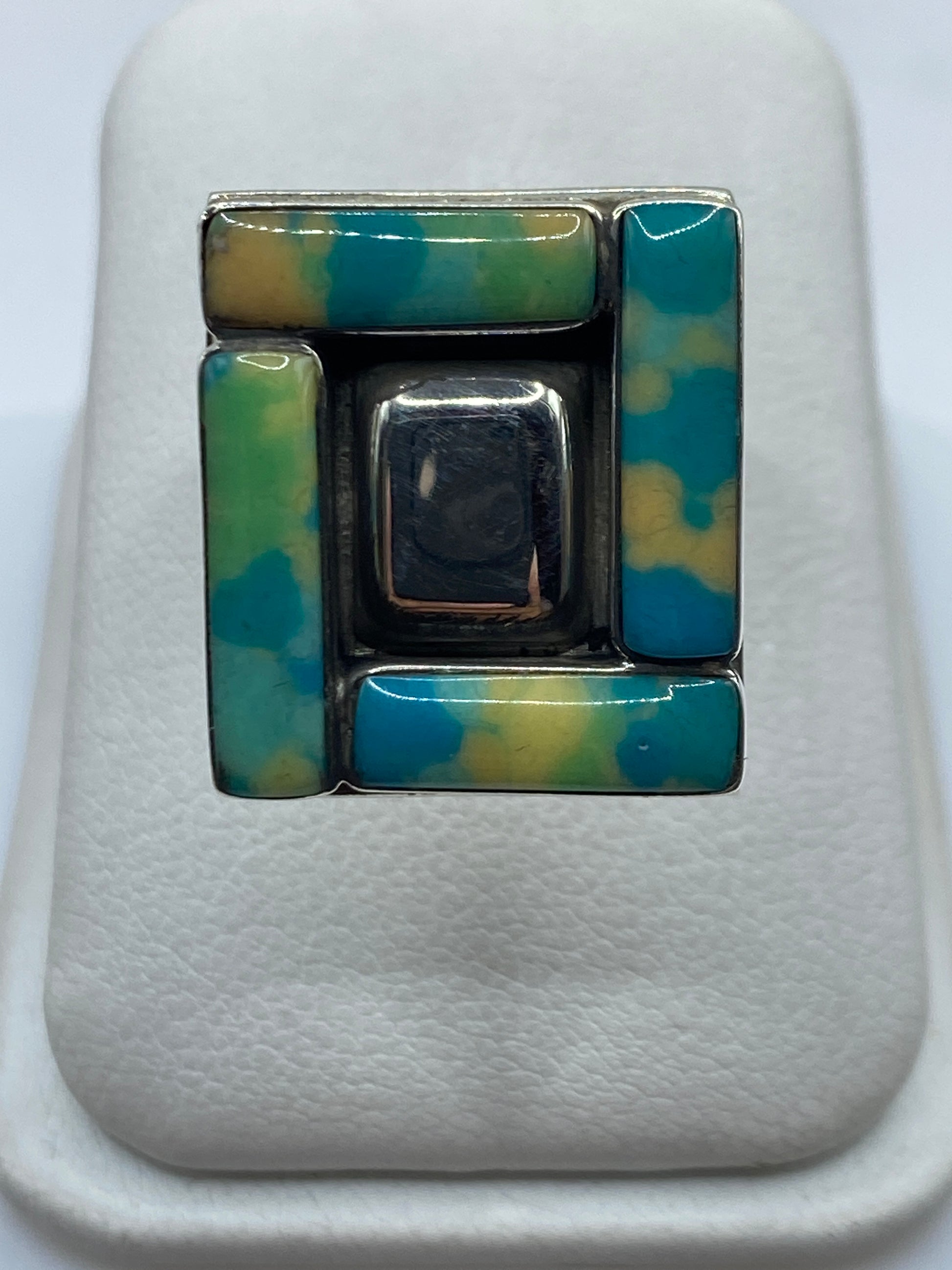 Anillo ajustable geométrico de plata con piedra central engastada, vista frontal en la mano