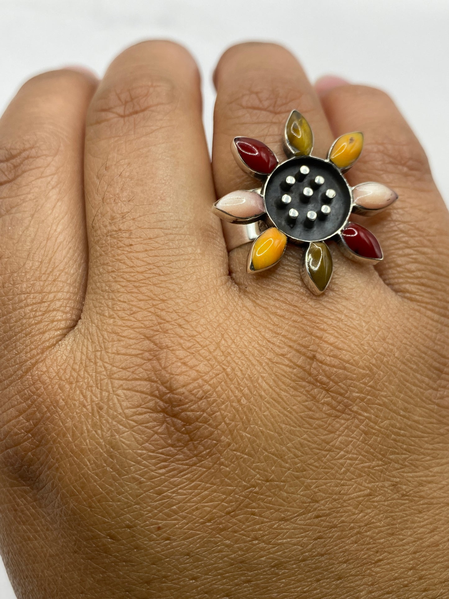 Anillo floral sobre fondo neutro destacando la geometría de los ocho pétalos engastados