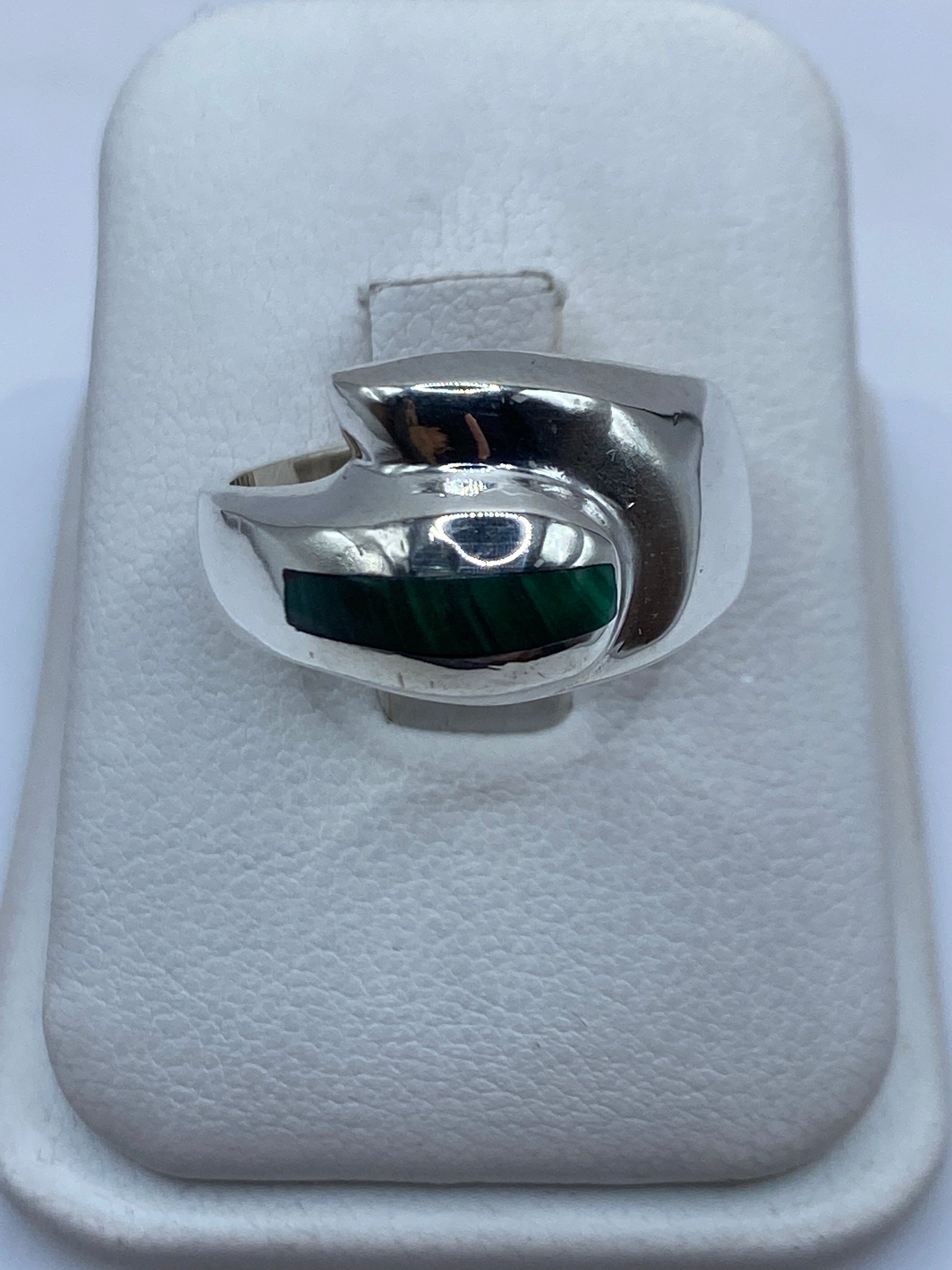 Anillo de plata con malaquita verde oscuro en la mano de un hombre, vista frontal