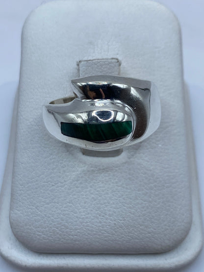 Anillo de plata con malaquita verde oscuro en la mano de un hombre, vista frontal