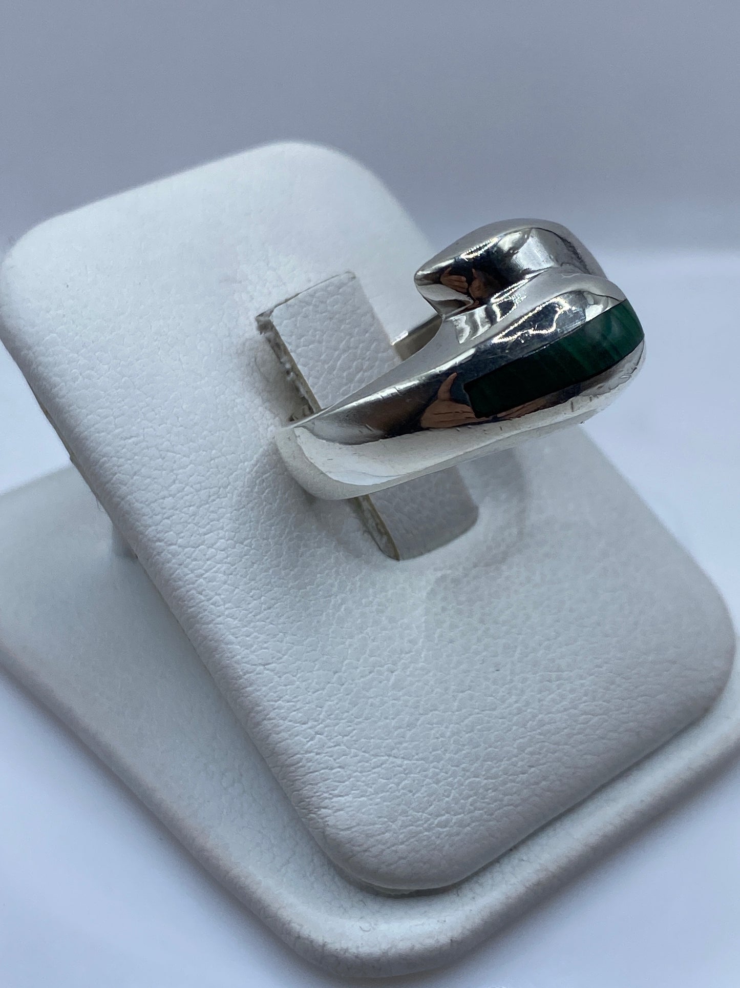 Detalle lateral del anillo solitario con banda de plata y piedra de malaquita pulida