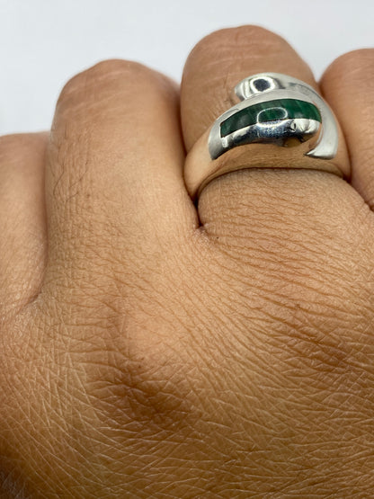 Anillo de malaquita y plata sobre fondo gris, mostrando los patrones naturales de la piedra