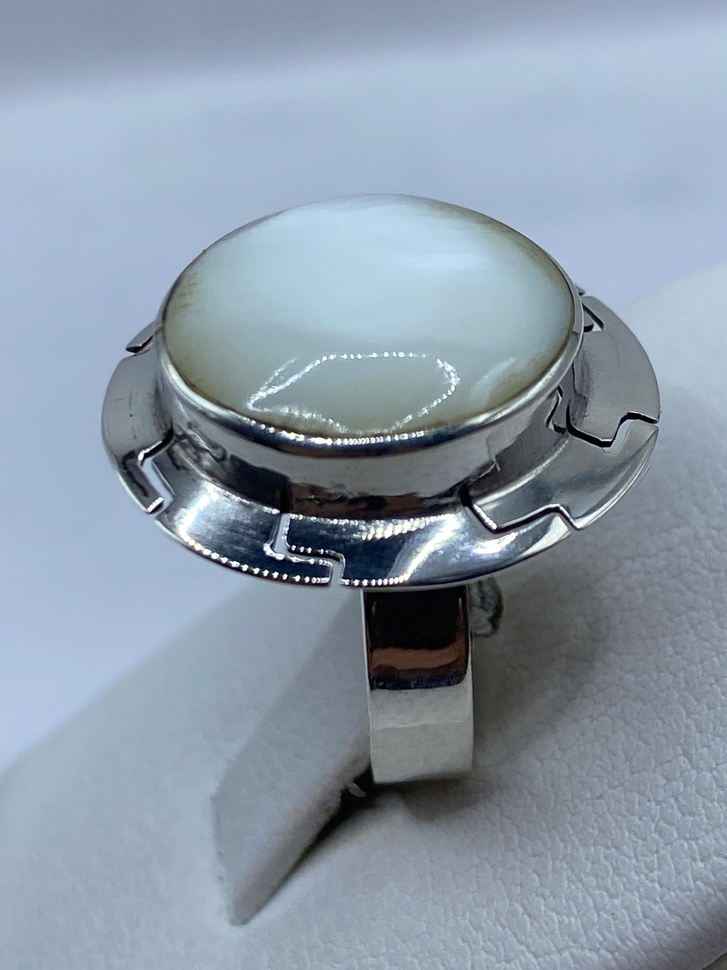 Anillo de perla en dedo, mostrando el diseño geométrico y el brillo de la gema