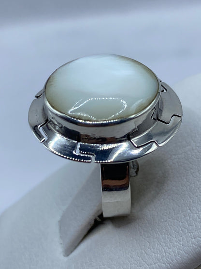 Anillo de perla en dedo, mostrando el diseño geométrico y el brillo de la gema