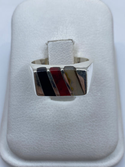 Anillo de plata con coral rojo en diseño geométrico sobre estuche blanco