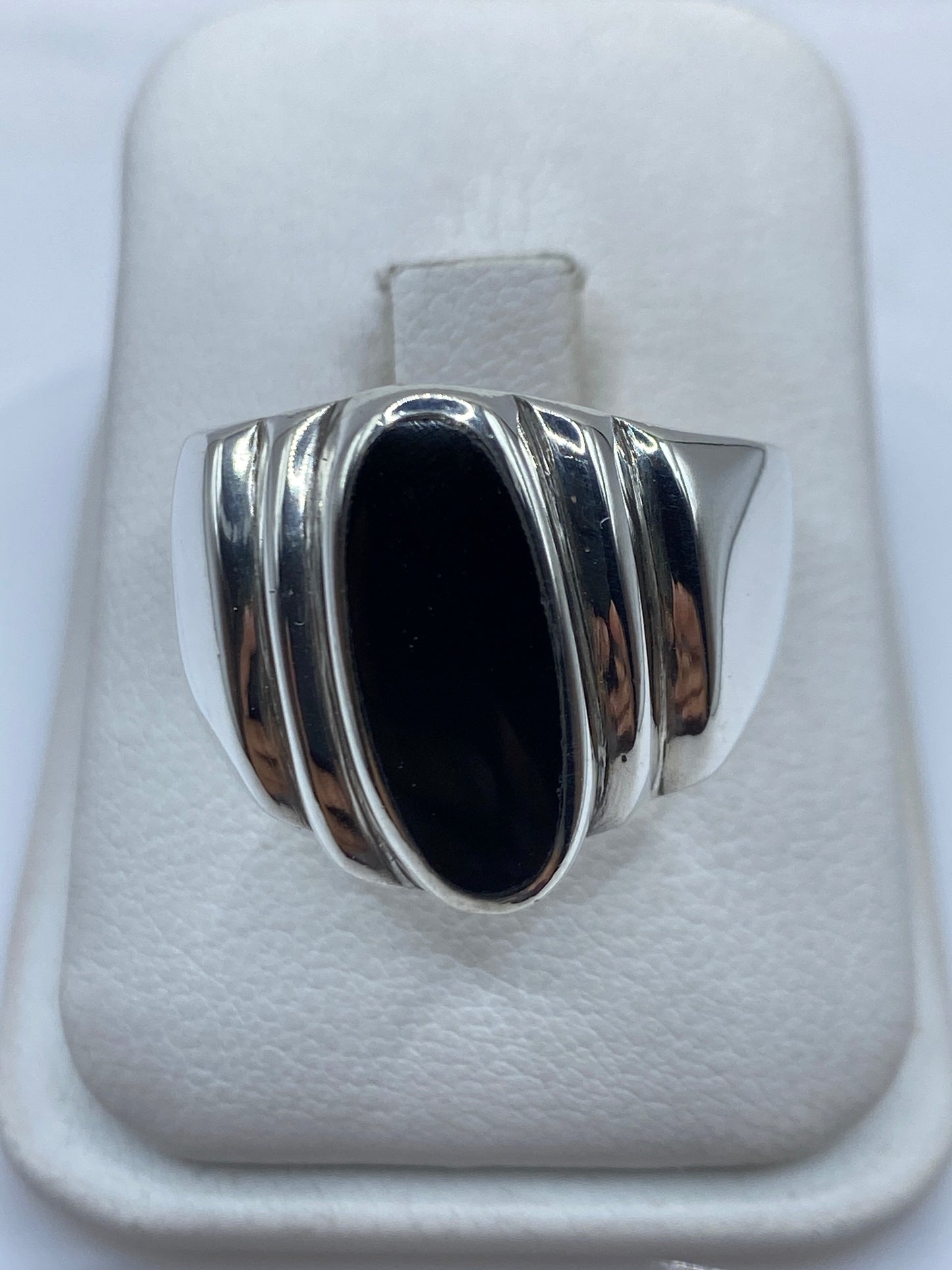 Anillo de plata con ónix negro oval en la mano de un hombre
