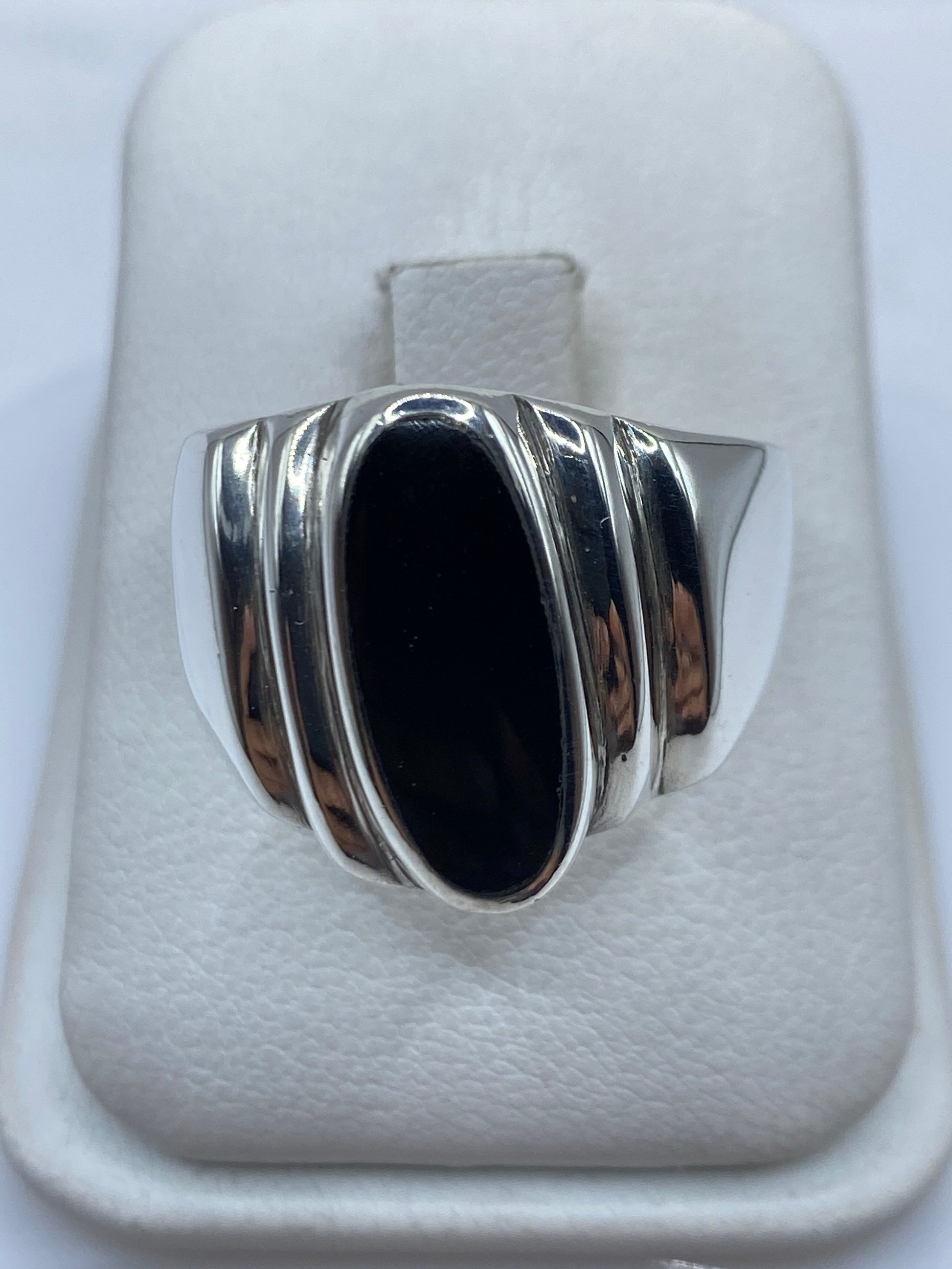 Anillo de plata con ónix negro oval en la mano de un hombre