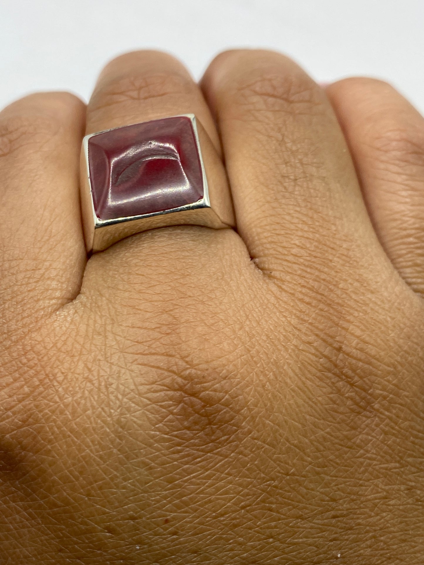 Anillo en dedo masculino mostrando el sello .925 y presencia de la piedra coral