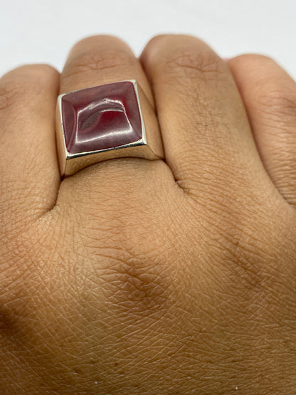 Anillo en dedo masculino mostrando el sello .925 y presencia de la piedra coral