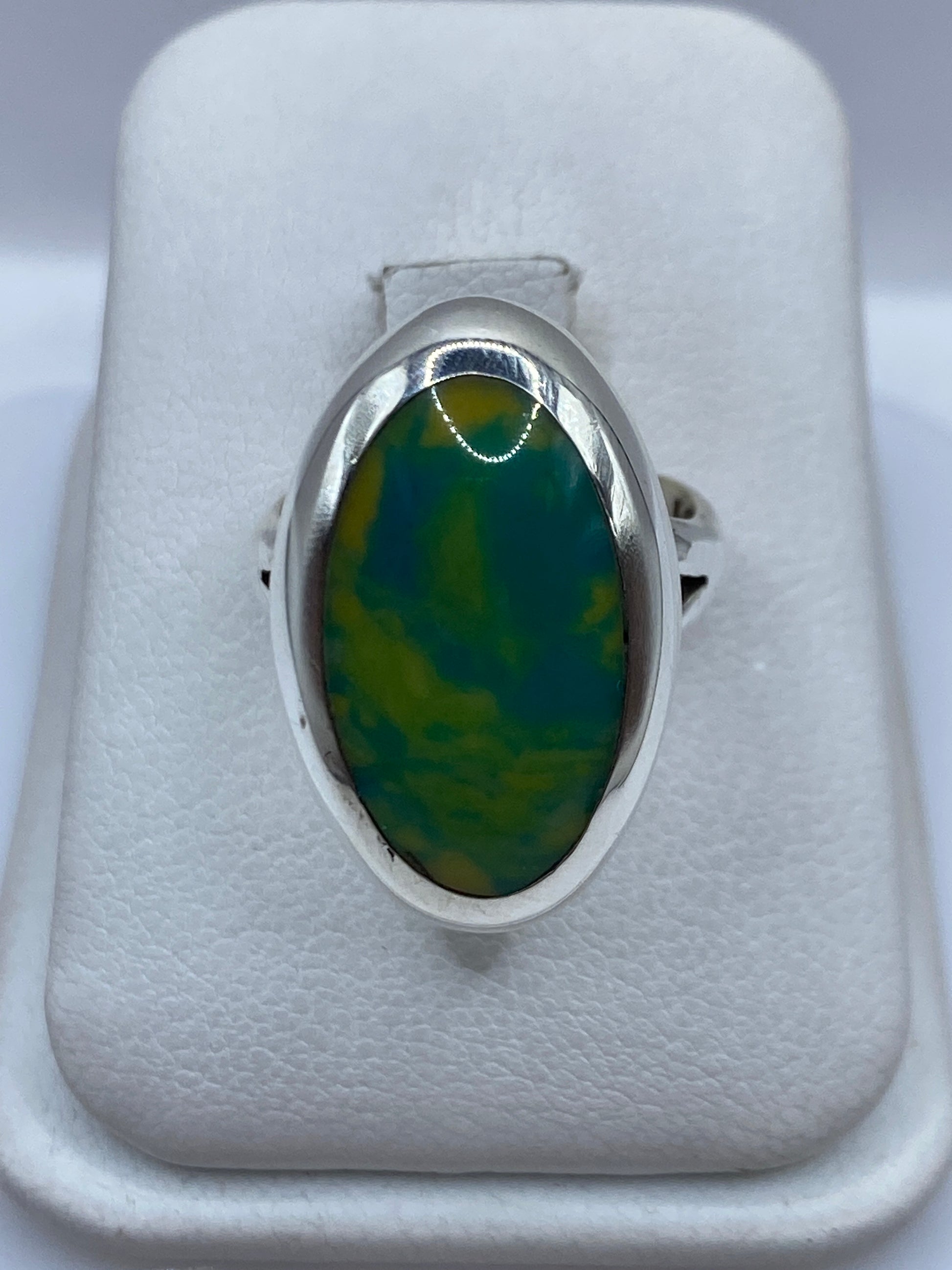 Anillo de plata con piedra multicolor verde y amarillo, vista frontal en estuche blanco