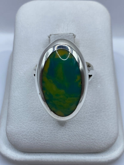 Anillo de plata con piedra multicolor verde y amarillo, vista frontal en estuche blanco