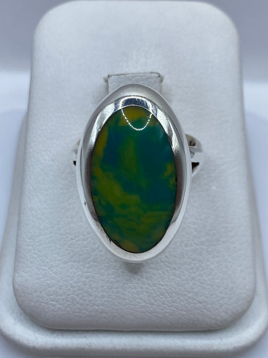 Anillo de plata con piedra multicolor verde y amarillo, vista frontal en estuche blanco