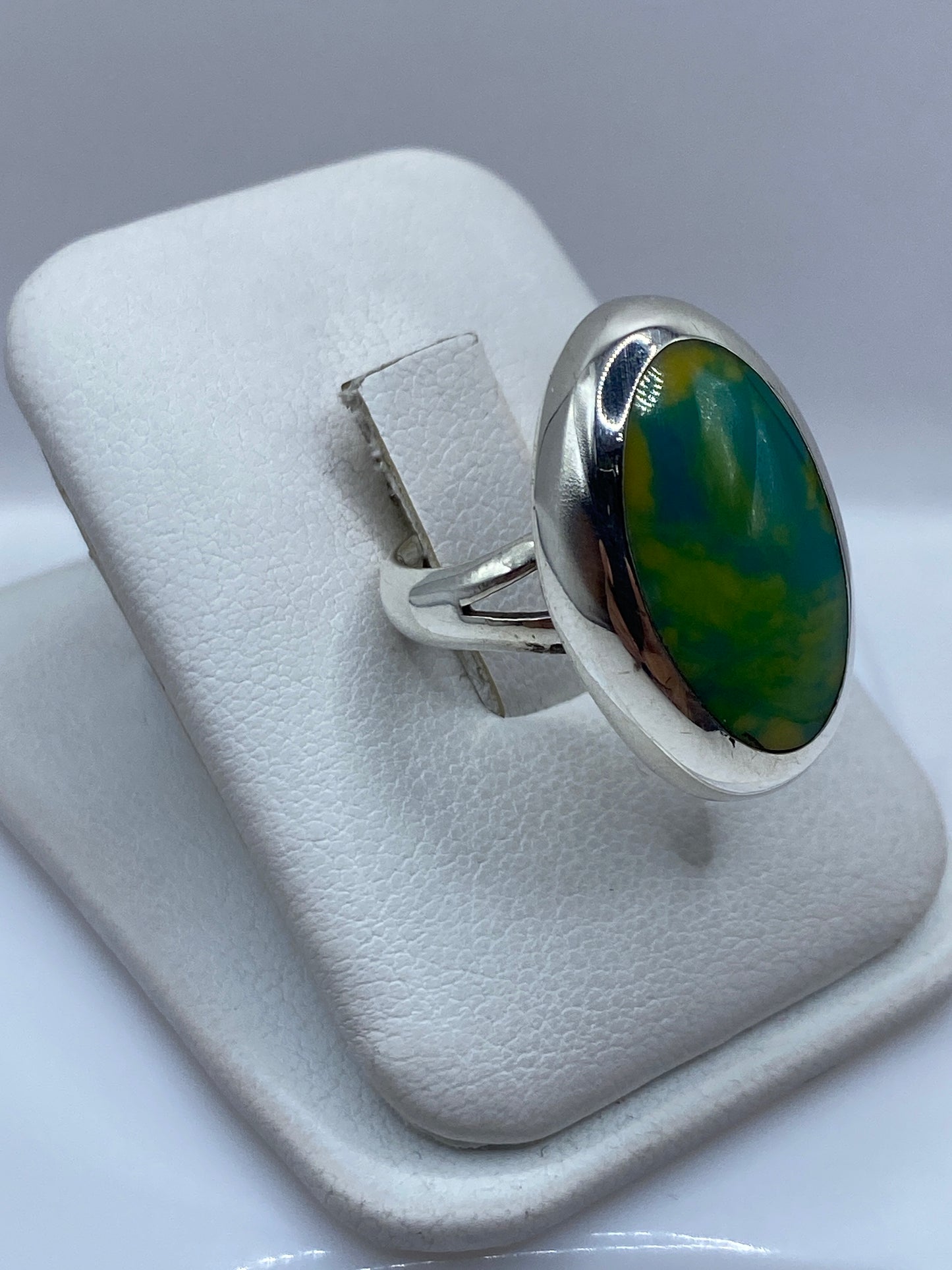 Anillo ovalado clásico de plata .925 en la mano, mostrando el pulido a espejo