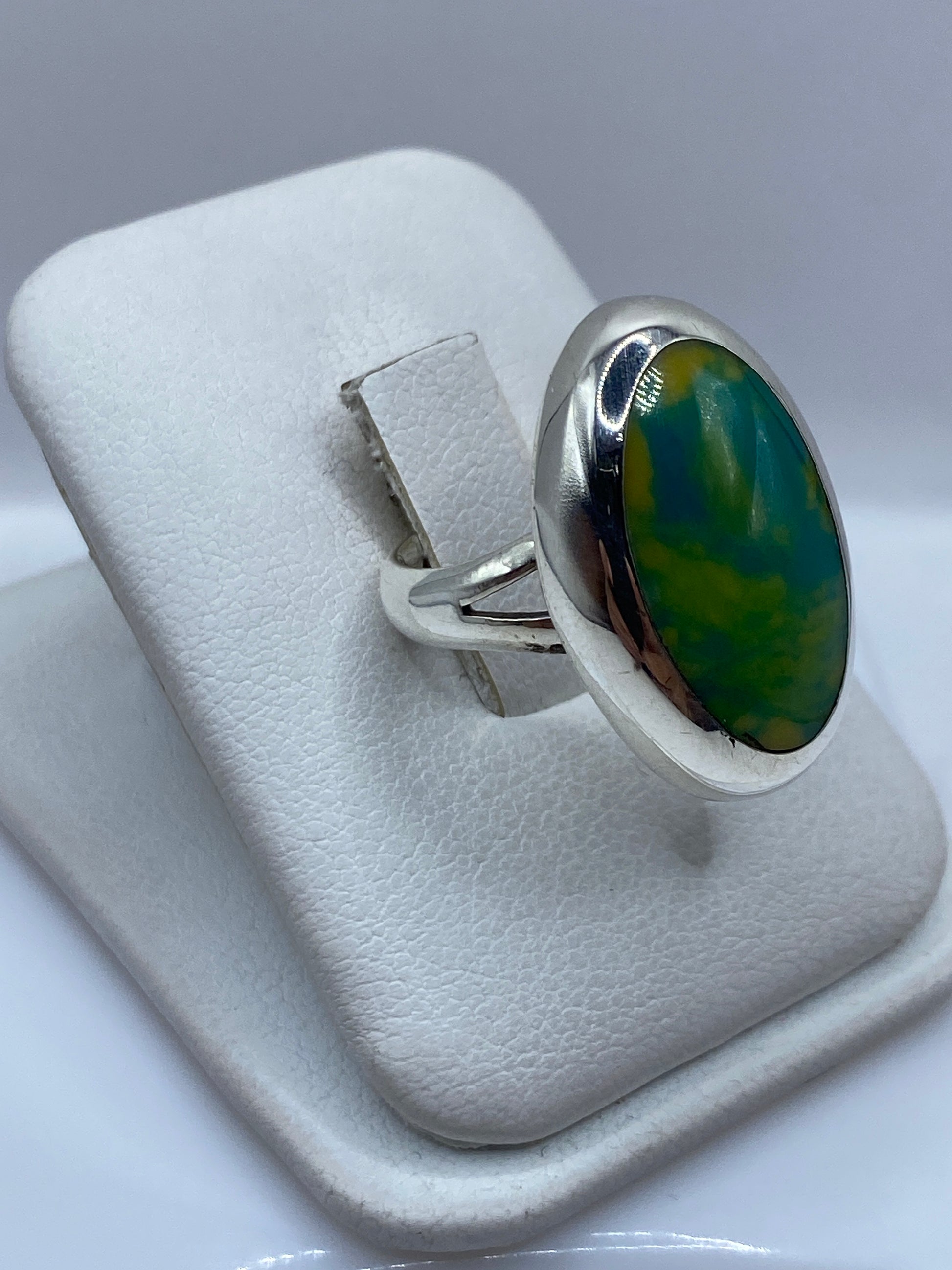 Anillo ovalado clásico de plata .925 en la mano, mostrando el pulido a espejo