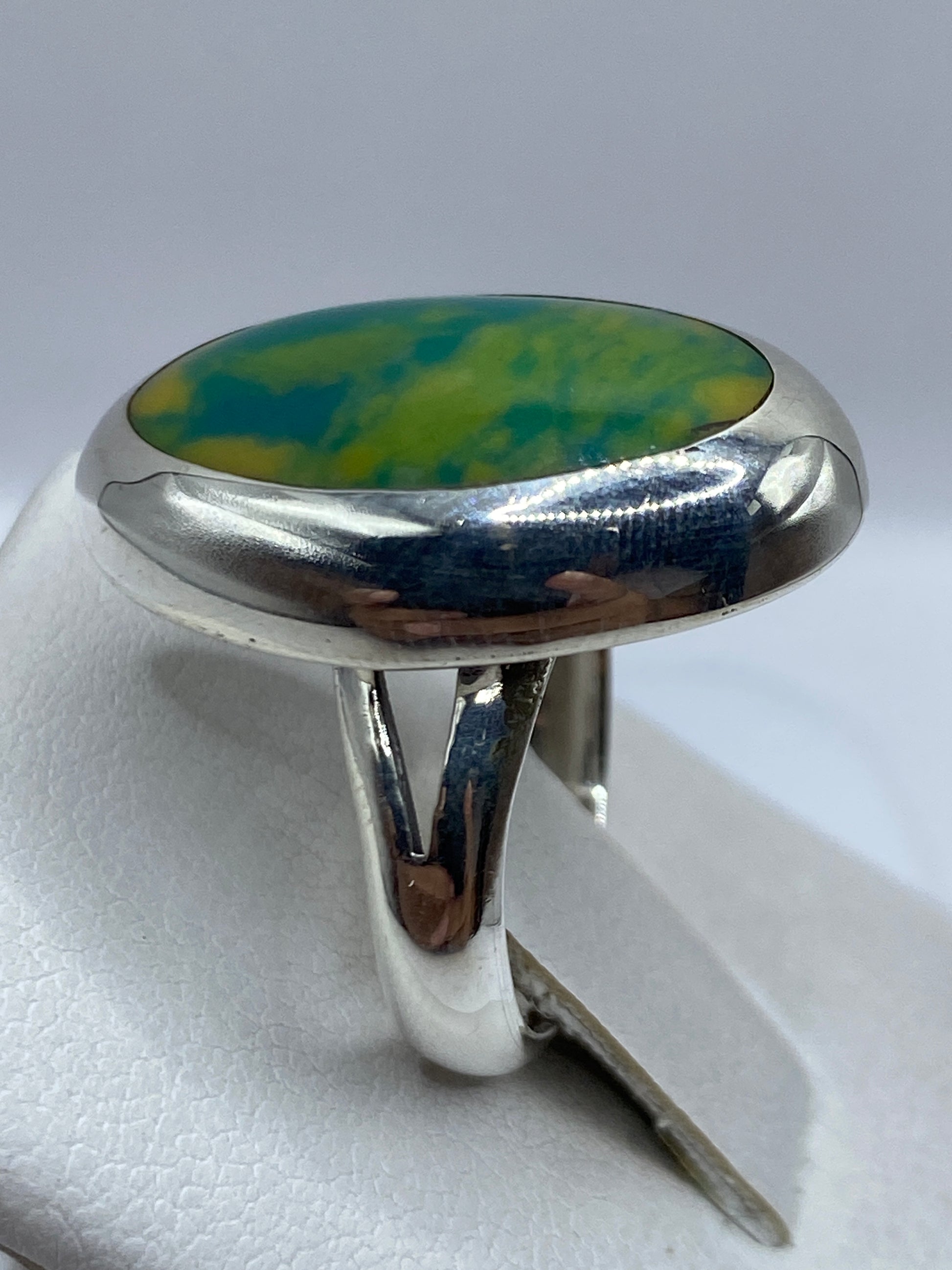 Detalle lateral del anillo de plata con piedra multicolor en tonos naturales