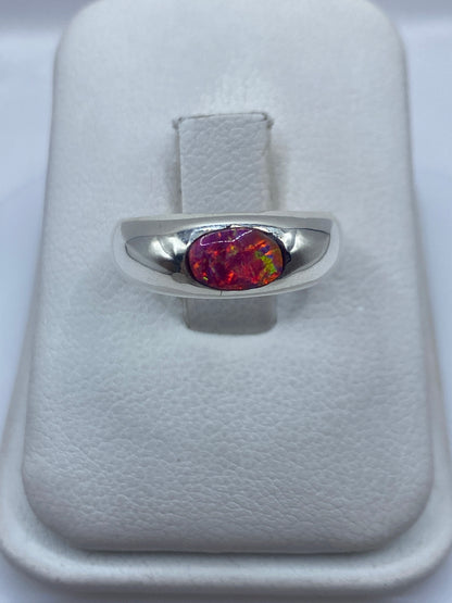 Anillo de plata con ópalo de fuego rosa mostrando juego de color naranja y amarillo