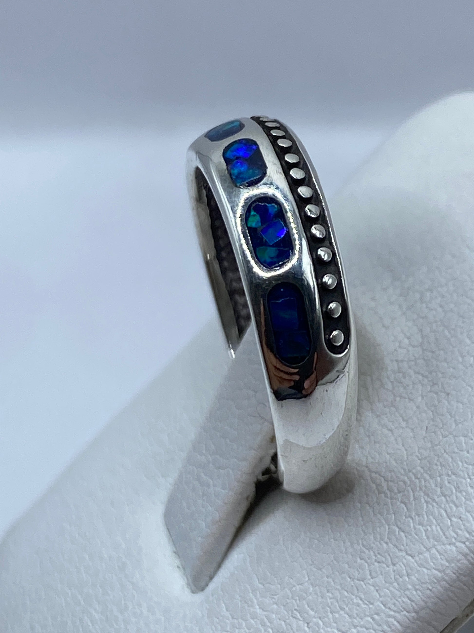 Anillo minimalista .950 en la mano mostrando el juego de colores del ópalo