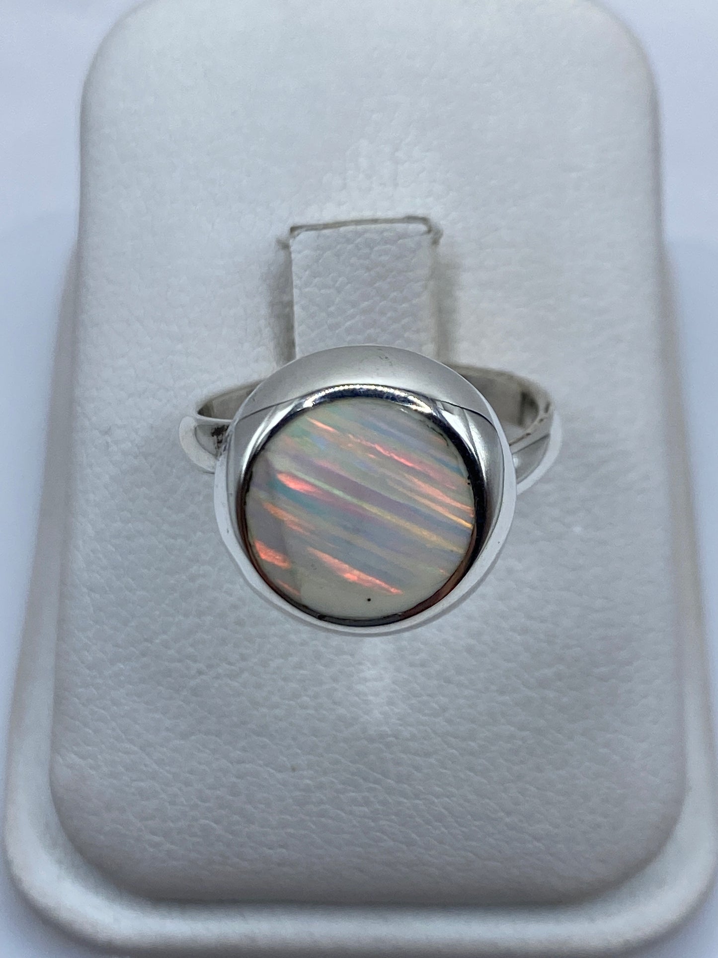 Anillo de plata ajustable con ópalo de fuego natural mostrando fuego multicolor rojo, verde y amarillo
