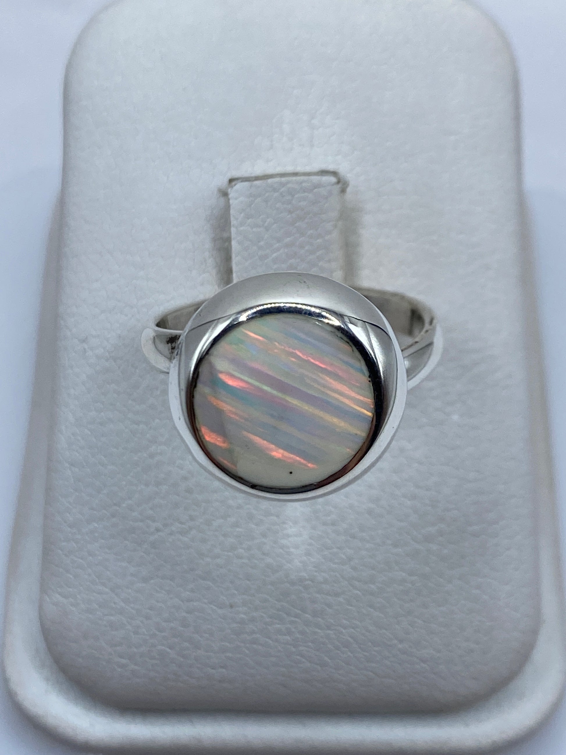 Anillo de plata ajustable con ópalo de fuego natural mostrando fuego multicolor rojo, verde y amarillo