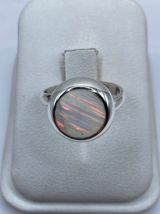 Anillo de plata ajustable con ópalo de fuego natural mostrando fuego multicolor rojo, verde y amarillo