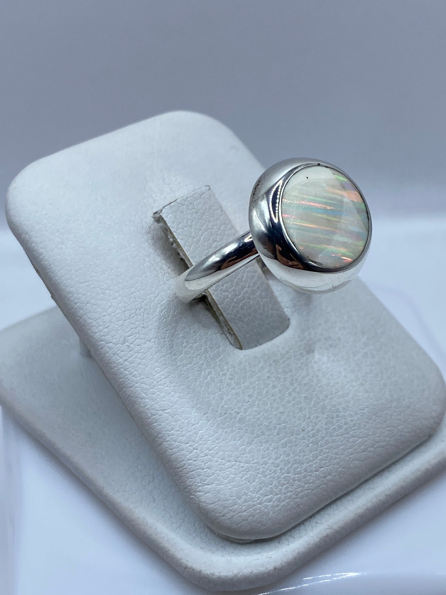 Vista lateral del anillo solitario de ópalo en plata .925 con engaste protector
