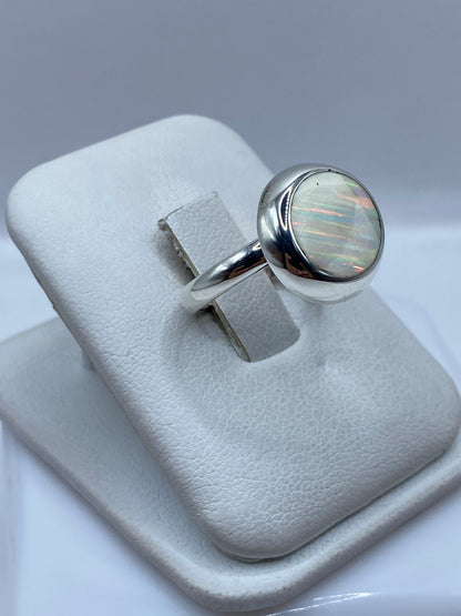 Vista lateral del anillo solitario de ópalo en plata .925 con engaste protector