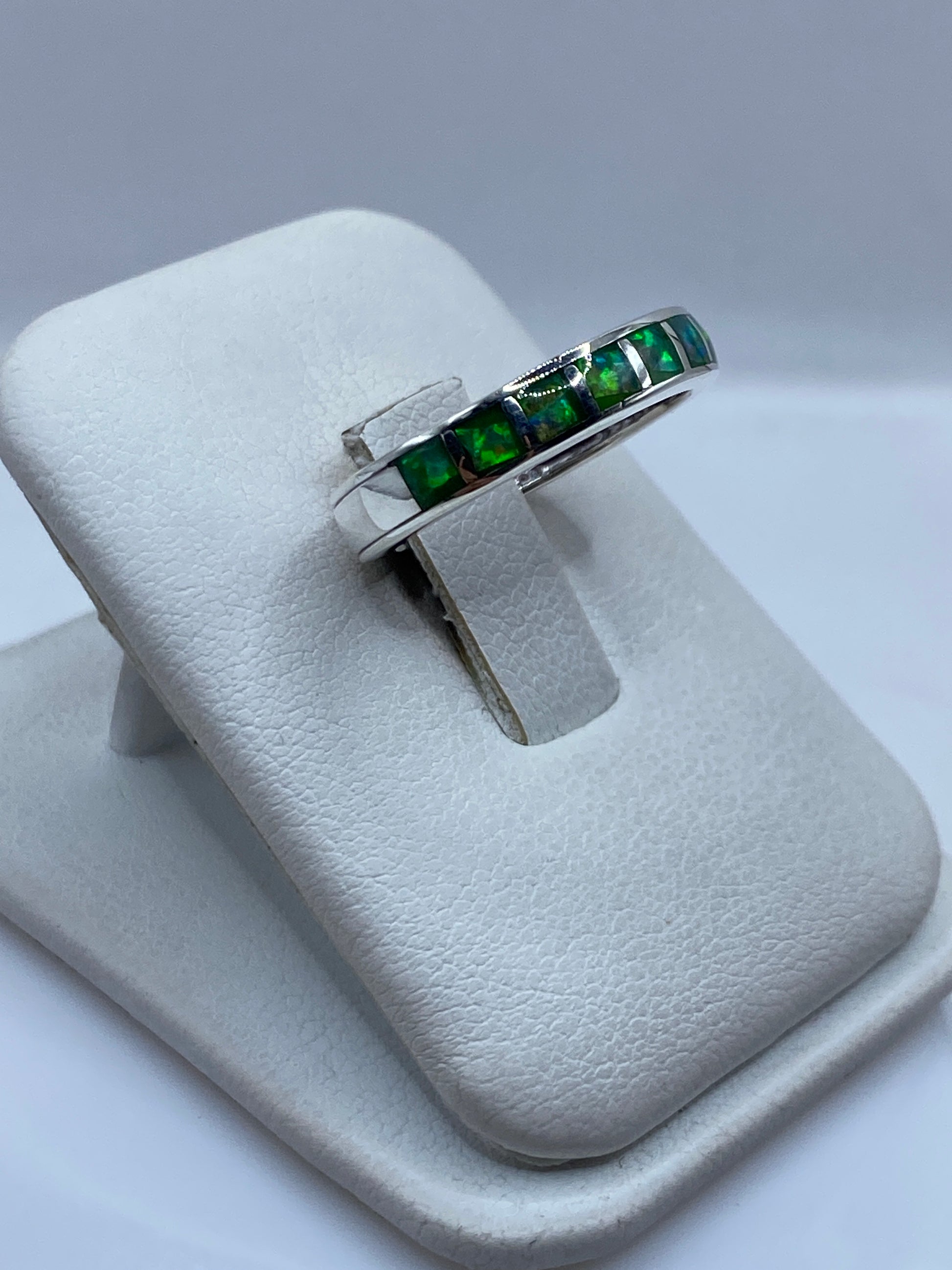 Lateral del anillo unisex mostrando la banda pulida y el engaste del ópalo natural