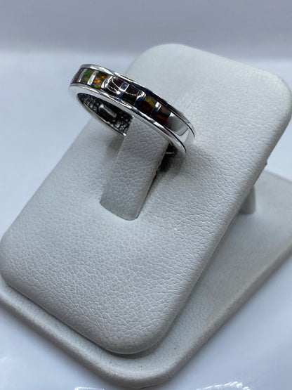 Vista lateral del anillo unisex de plata con ópalo de fuego en tonos rojos y dorados