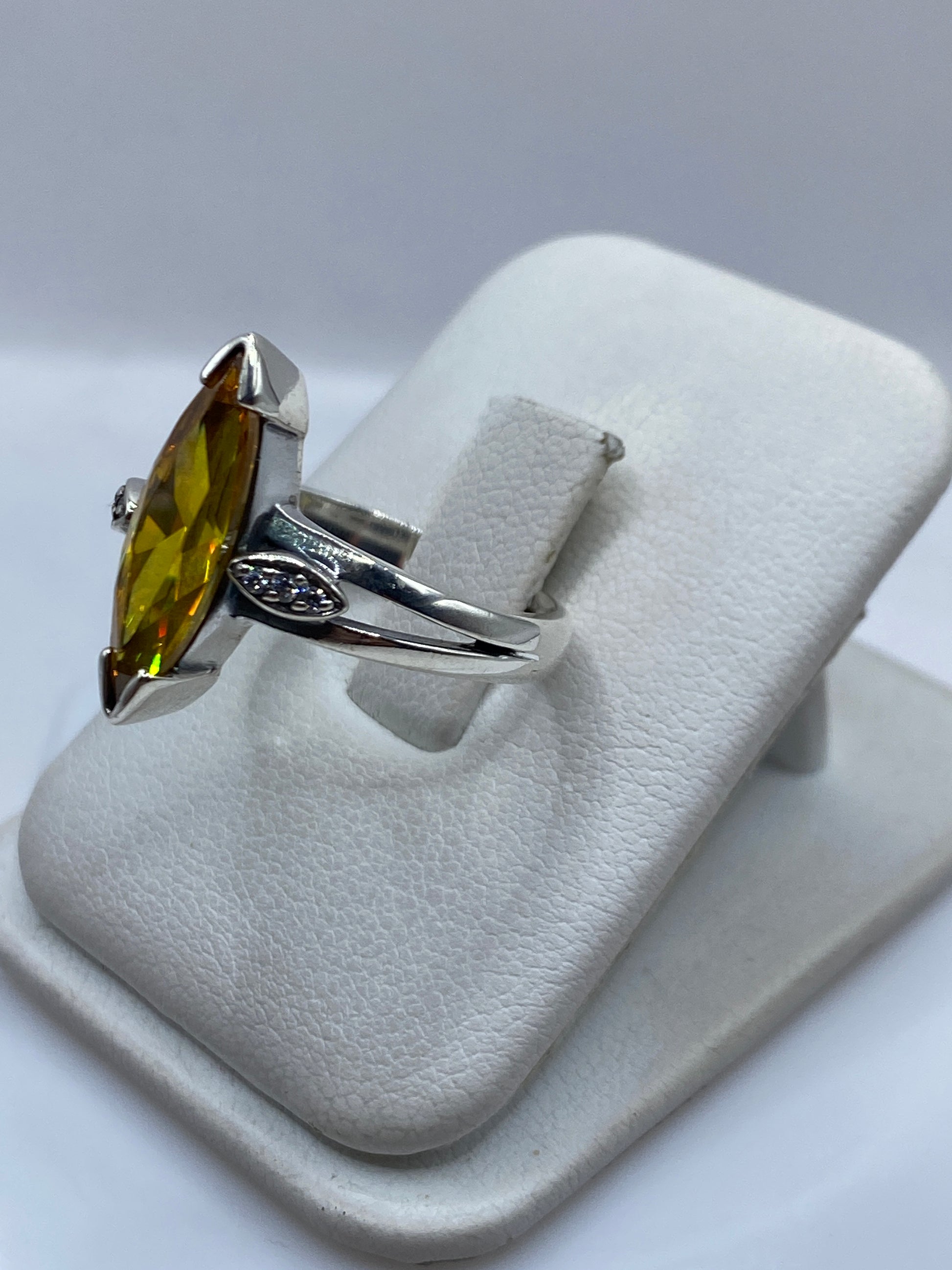 Detalle lateral del anillo mostrando el engaste y las volutas de plata .925
