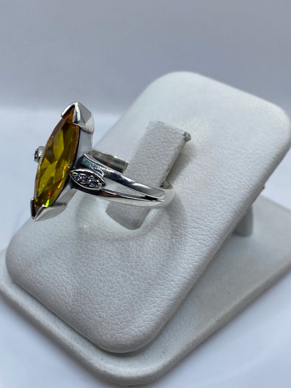 Detalle lateral del anillo mostrando el engaste y las volutas de plata .925