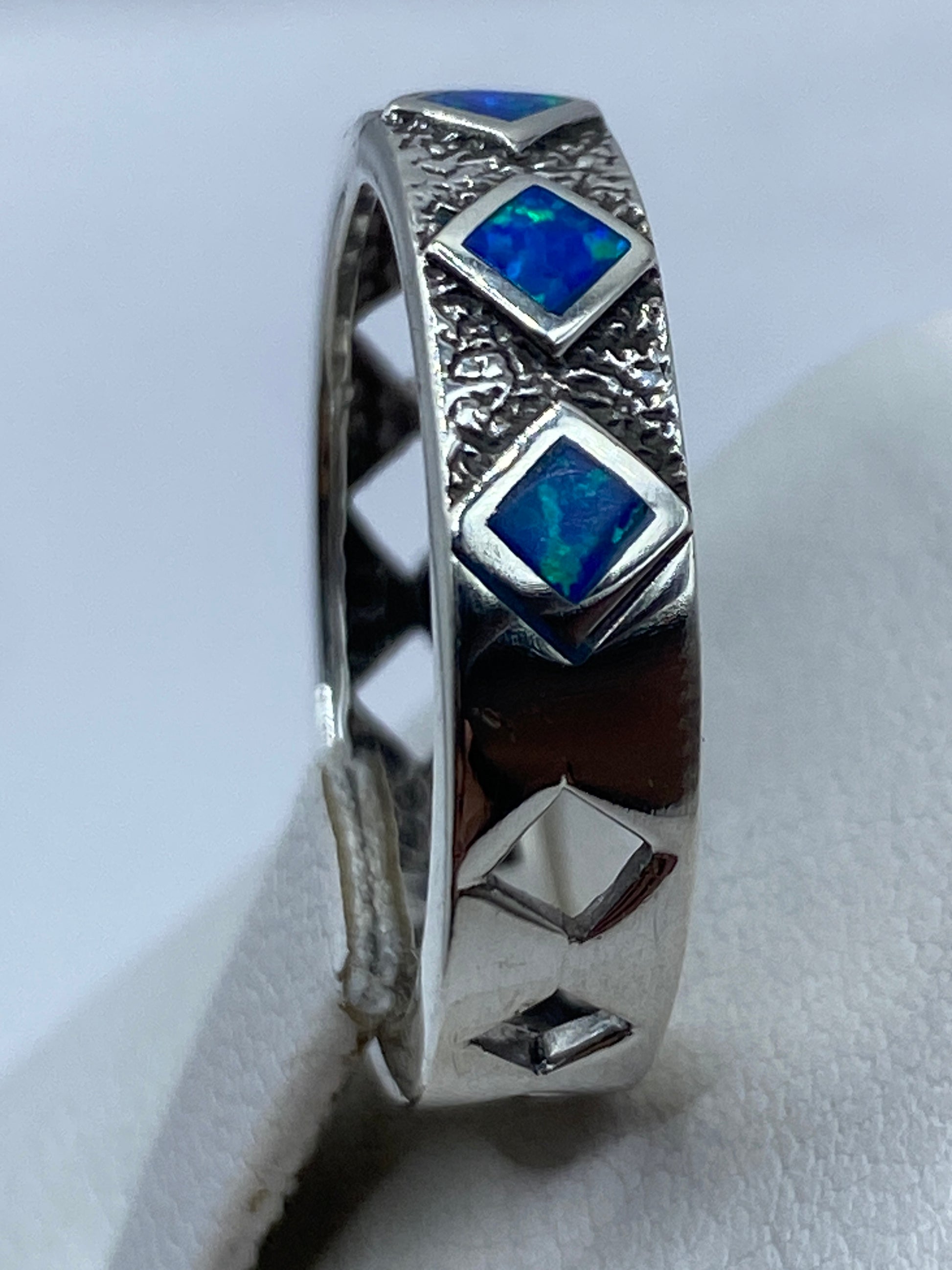 Detalle del ópalo de fuego azul engastado en plata pura .950 con juego de luz