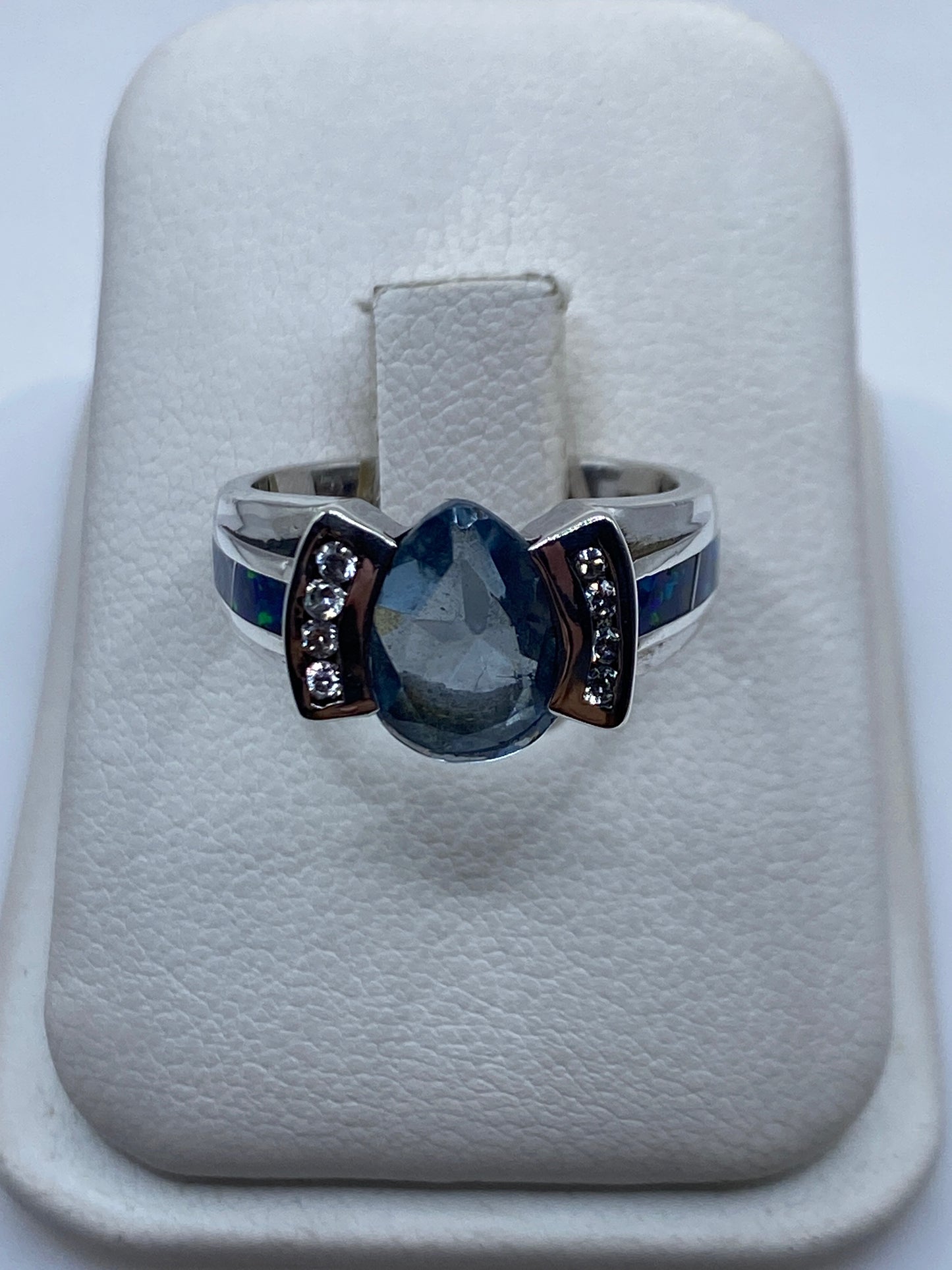 Anillo de plata .925 con ópalo de fuego azul en facetas, ancho de banda 4 mm, sobre fondo blanco