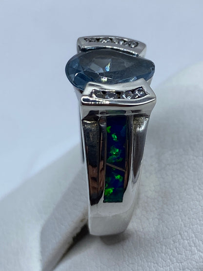 Anillo solitario de ópalo azul colocado en mano, vista lateral donde se ve la profundidad del engaste
