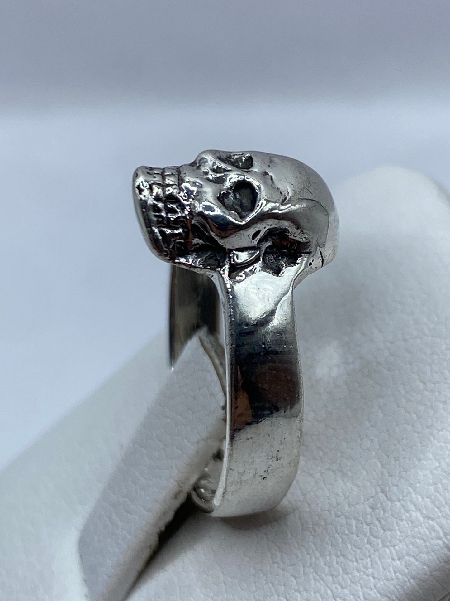 Anillo calavera en la mano de un hombre adulto, uso cotidiano