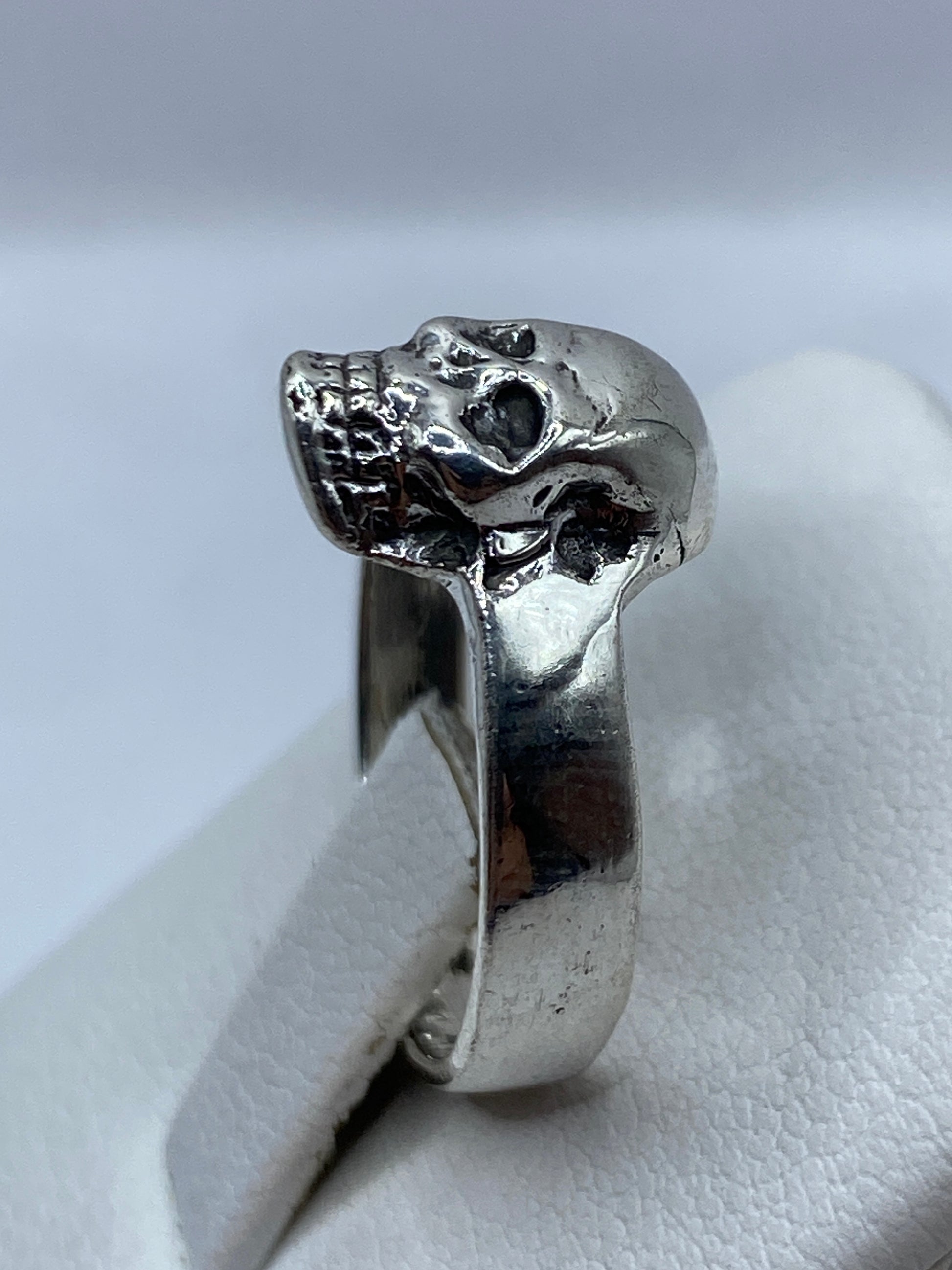 Anillo calavera en la mano de un hombre adulto, uso cotidiano