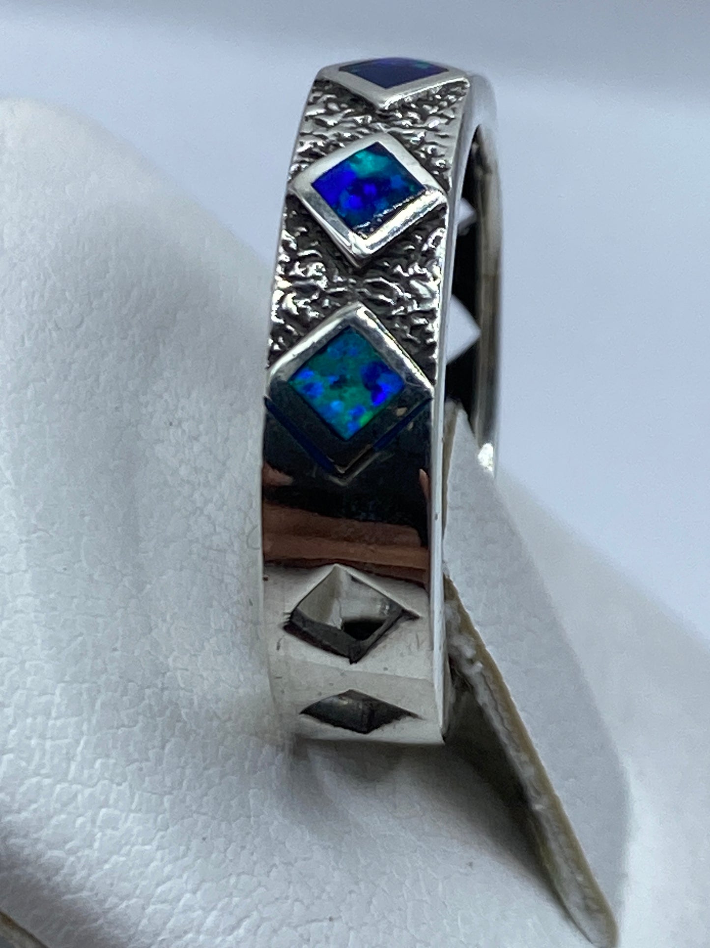 Ópalo de fuego azul engastado en plata, sobre mano femenina