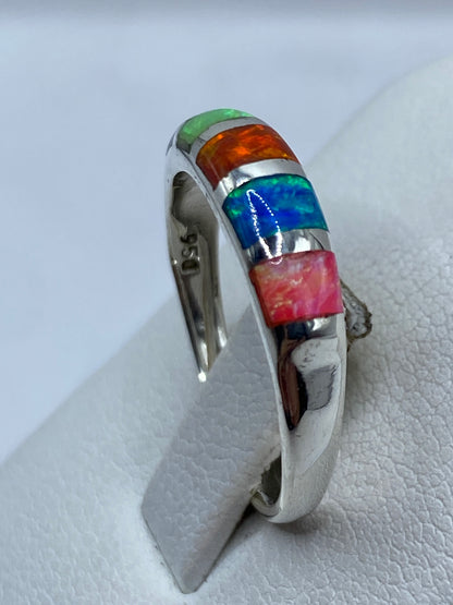 Detalle del ópalo de fuego con reflejos verdes, rojos y azules en la mano
