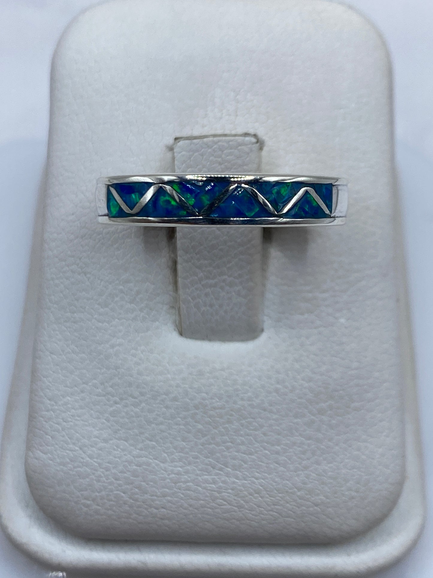 Anillo de plata .950 con ópalo de fuego azul en diseño geométrico sobre cojín de terciopelo